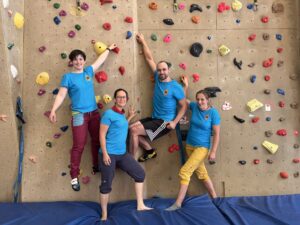 Ein Team des SMF steht an der Kletterwand und lächelt in die Kamera