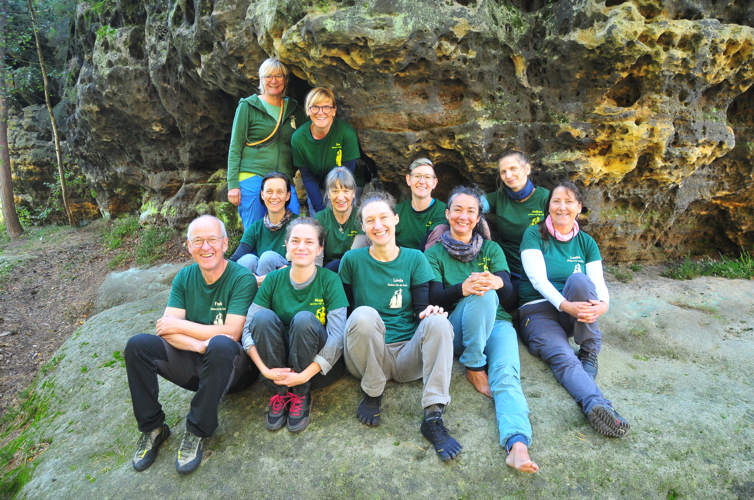 Das Team von Climbing for all vor einem Fels sitzend